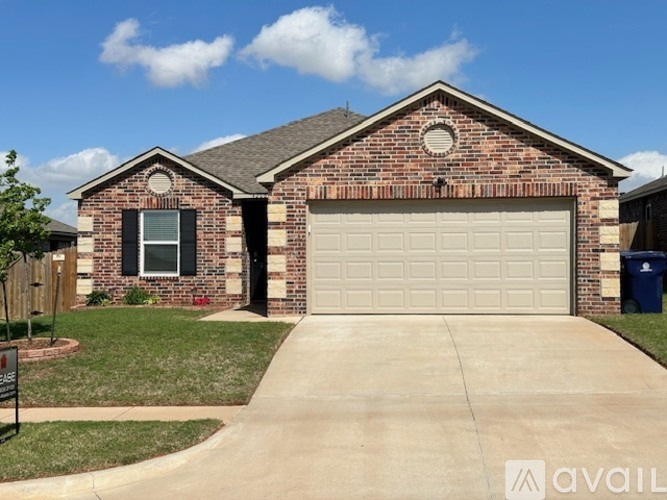 A brick house with a garage door and a sign that says "available".