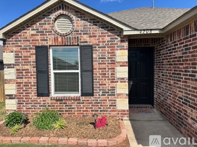A brick house with a black door and window.