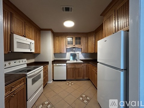 A kitchen with wooden cabinets and a white refrigerator.