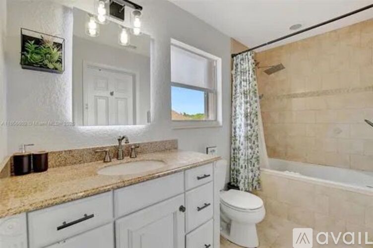 A bathroom with a sink, toilet, and bathtub.