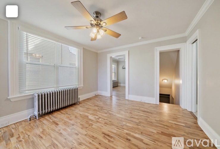 A room with wooden floors and a ceiling fan.