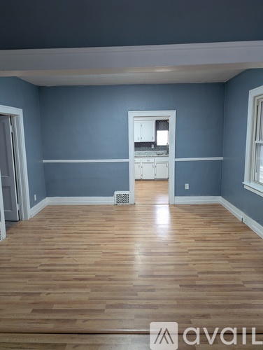 A room with blue walls and wooden floors is available for rent.