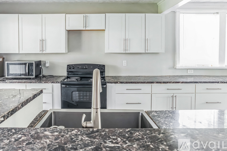 A kitchen with a sink and a stove top oven.