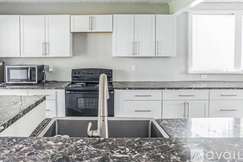 A kitchen with a sink and a stove top oven.