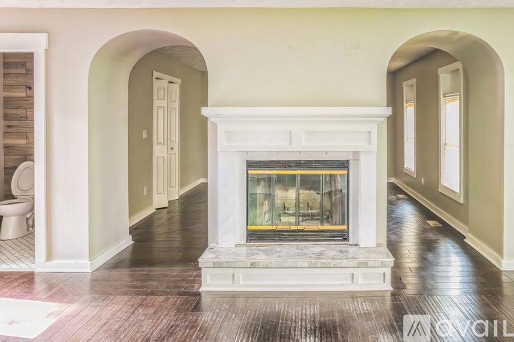 A living room with a fireplace and hardwood floors.
