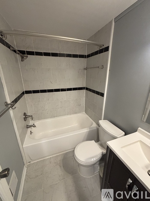 A bathroom with a white tub, toilet, and sink.