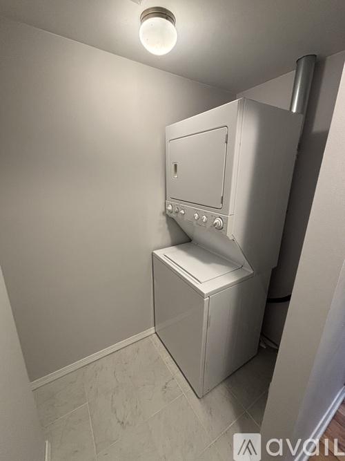 A white portable toilet is in a corner of a room.