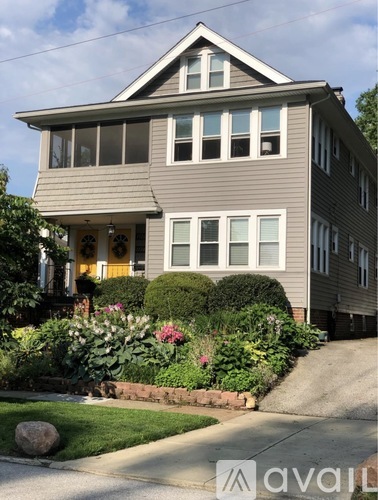 A house with a grey siding and a yellow door.