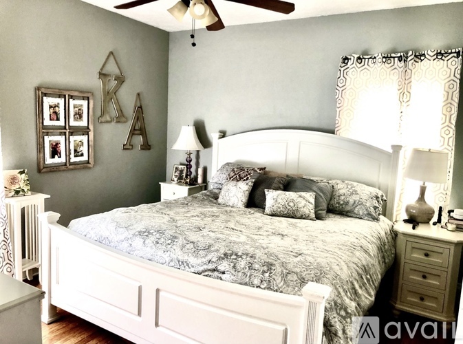 A bedroom with a bed, nightstand, and a ceiling fan.