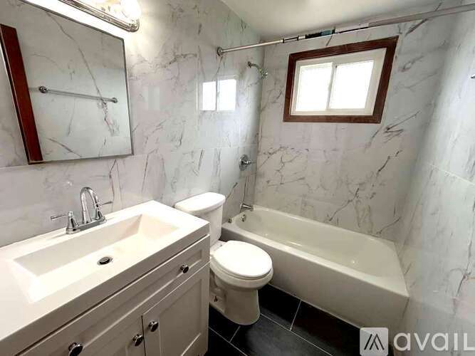 A bathroom with a marble wall and a white sink.