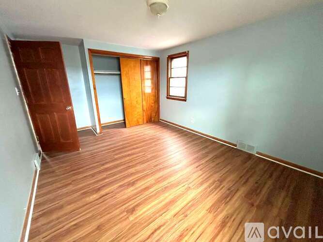 A room with wooden flooring and a door.