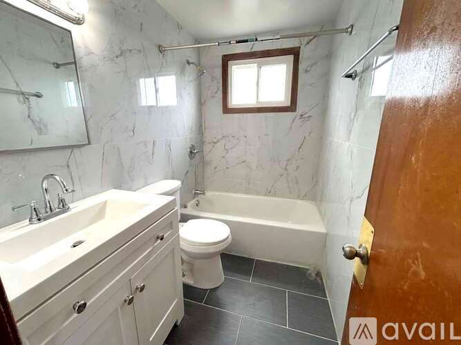 A bathroom with a toilet, sink, and bathtub.