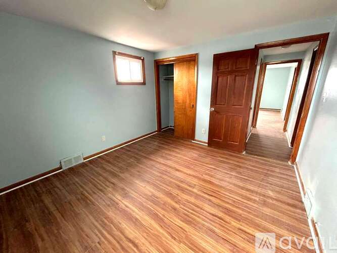 A room with wooden flooring and two doors.