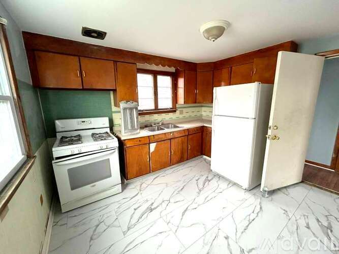 A kitchen with a white refrigerator, white stove, and white oven.