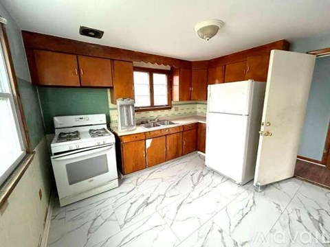 A kitchen with a white refrigerator, white stove, and white oven.