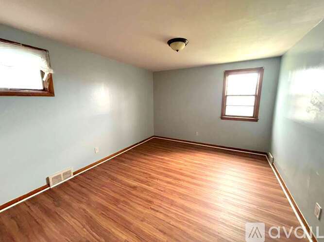 A room with wooden flooring and a window.