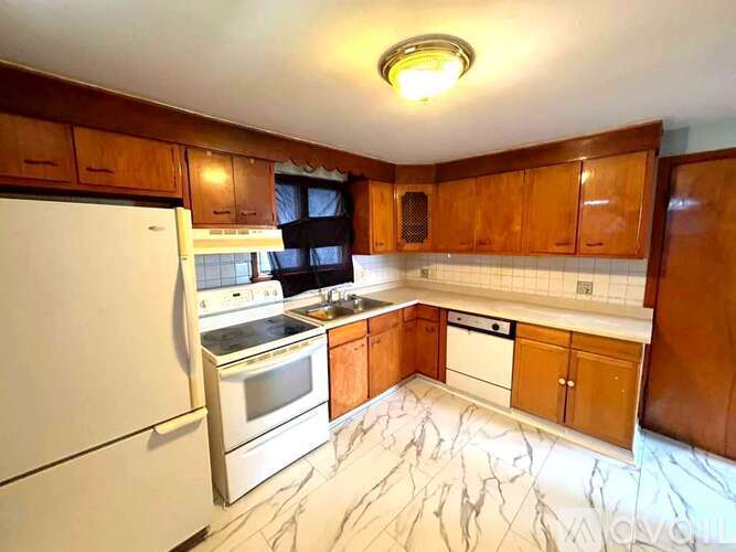 A kitchen with wooden cabinets and a white refrigerator.