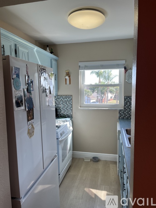 A kitchen with a white fridge and a window.