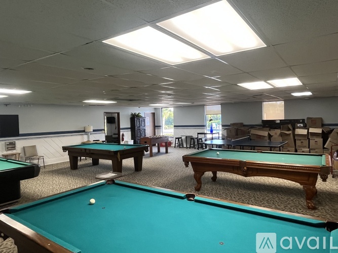 A pool table with a green cloth and a white ball in the middle.