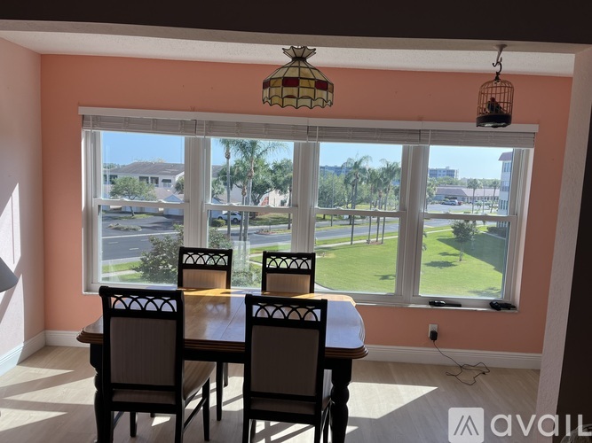 A dining room with a table and chairs and a view of the outside.