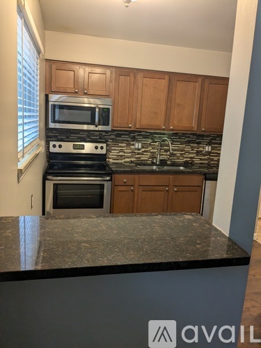 A kitchen with granite countertops and wooden cabinets.