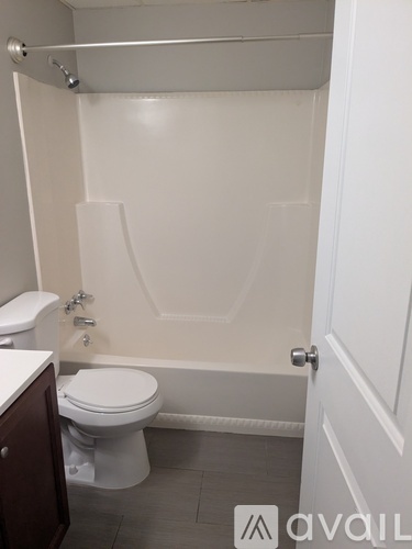 A white toilet sits next to a bathtub in a bathroom.
