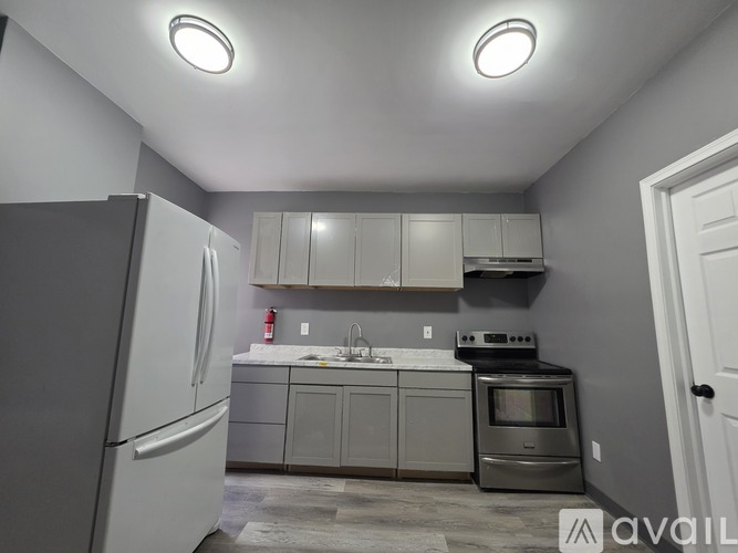 A kitchen with a white refrigerator and a stainless steel oven.