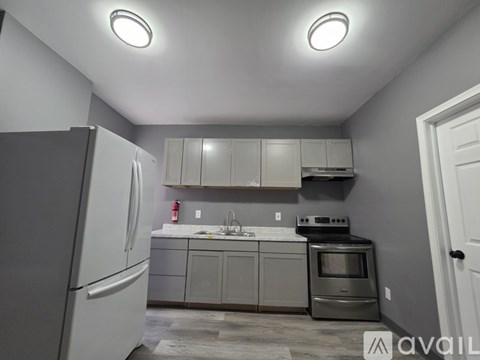 A kitchen with a white refrigerator and a stainless steel oven.