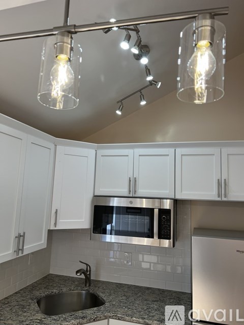 A kitchen with a sink, microwave, and cabinets.