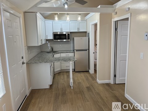 A kitchen with white cabinets and a granite countertop.