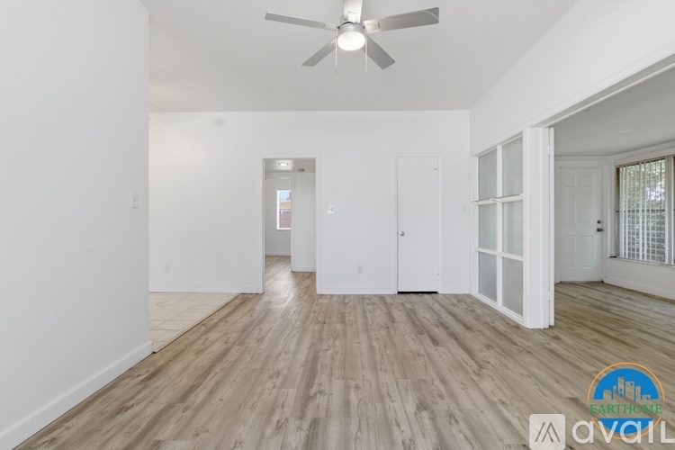 A spacious room with a ceiling fan and wooden flooring.