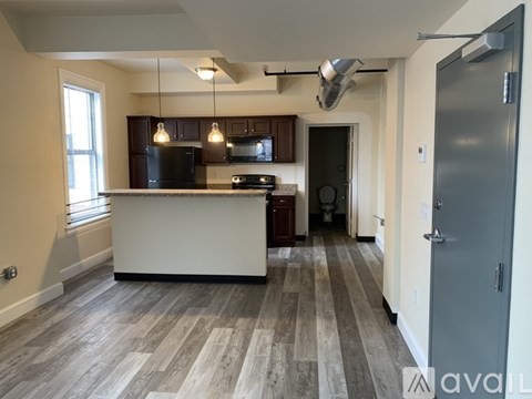 A kitchen with a white counter and wooden floors.