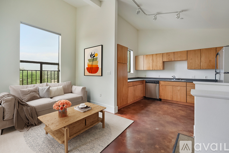 A living room with a couch, a coffee table, and a painting of a pineapple on the wall.