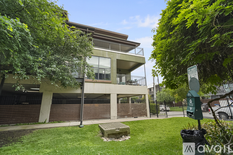 A modern building with a balcony and a sign in front of it.