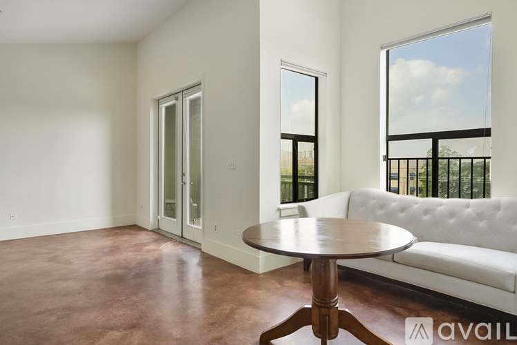 A living room with a white couch and a round table.