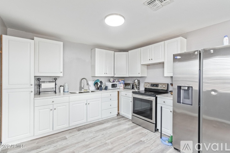 A kitchen with white cabinets and stainless steel appliances.