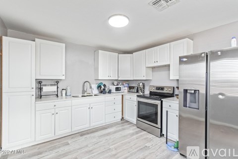 A kitchen with white cabinets and stainless steel appliances.