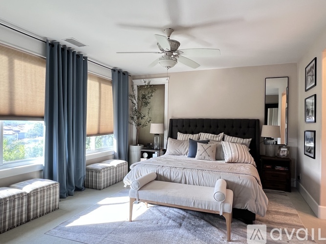 A bedroom with a large bed and a ceiling fan.