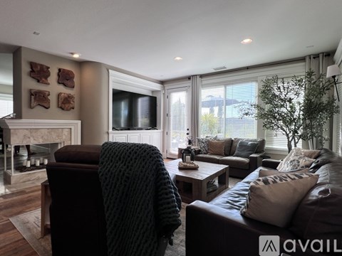 A living room with a brown couch and a fireplace.