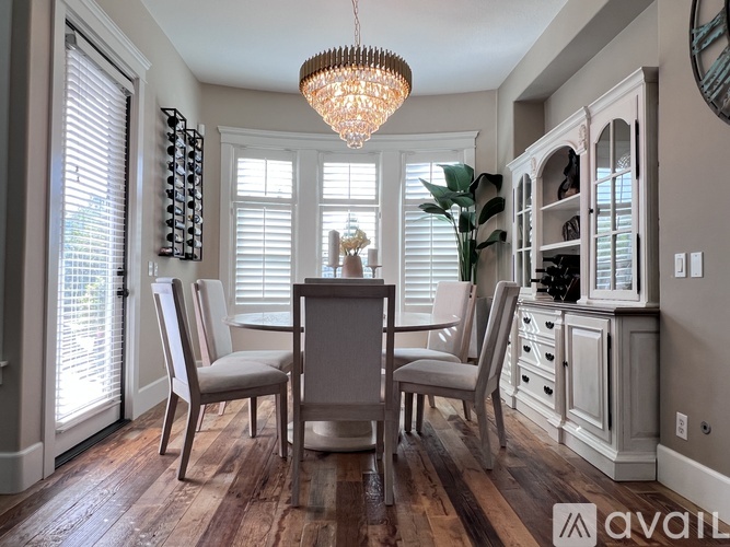 A dining room with a wooden table and chairs.