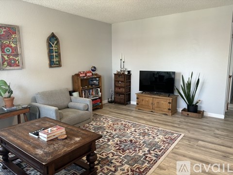 A living room with a wooden coffee table and a grey sofa.