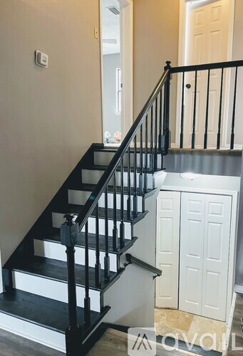 A staircase with black railings and white steps.