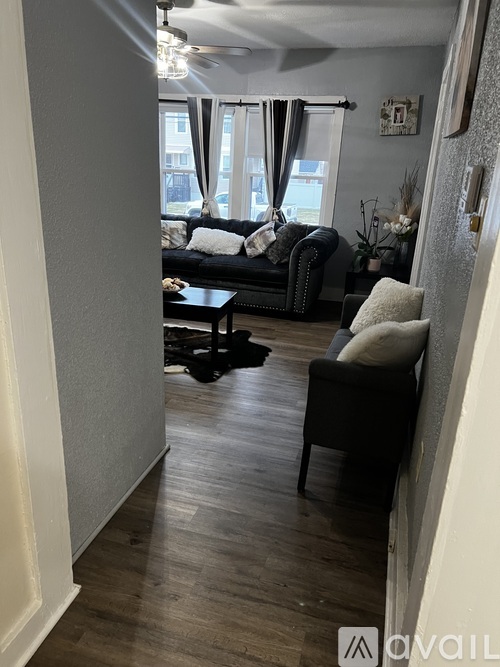 A living room with a black couch and a coffee table.