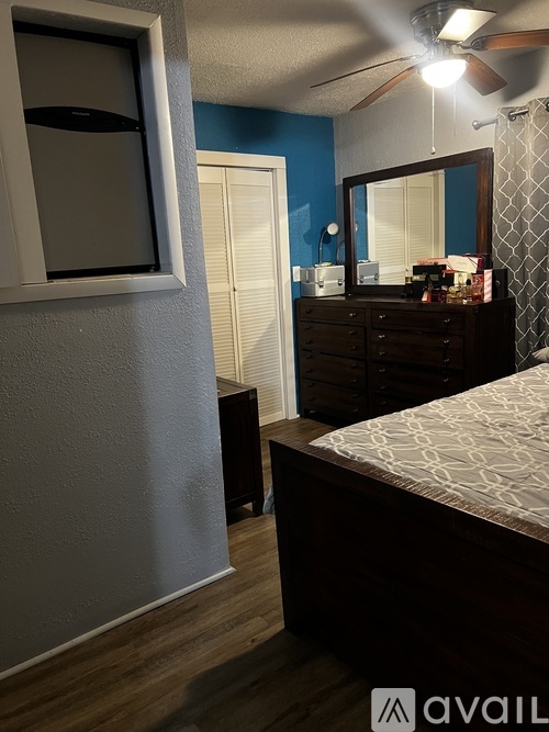 A bedroom with a bed, dresser, and mirror.