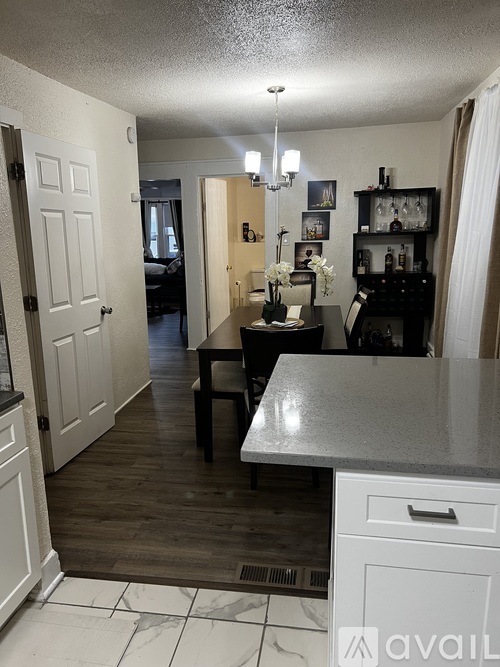 A kitchen with a white counter top and a white door.