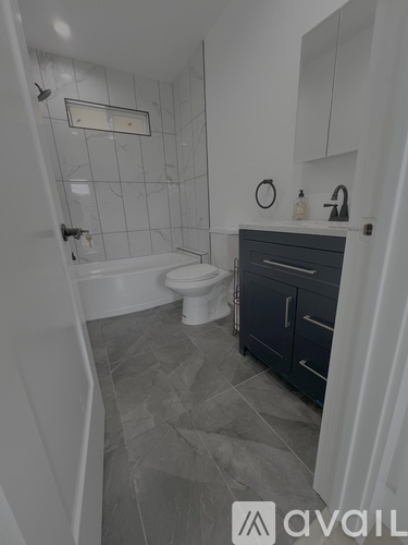 A bathroom with a toilet, sink, and a mirror.