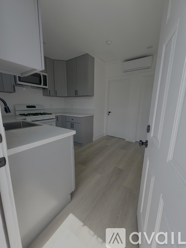 A kitchen with white cabinets and a white door.