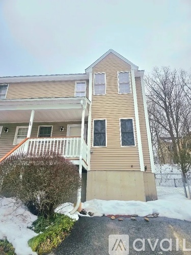 A two-story house with a brown siding and white trim.