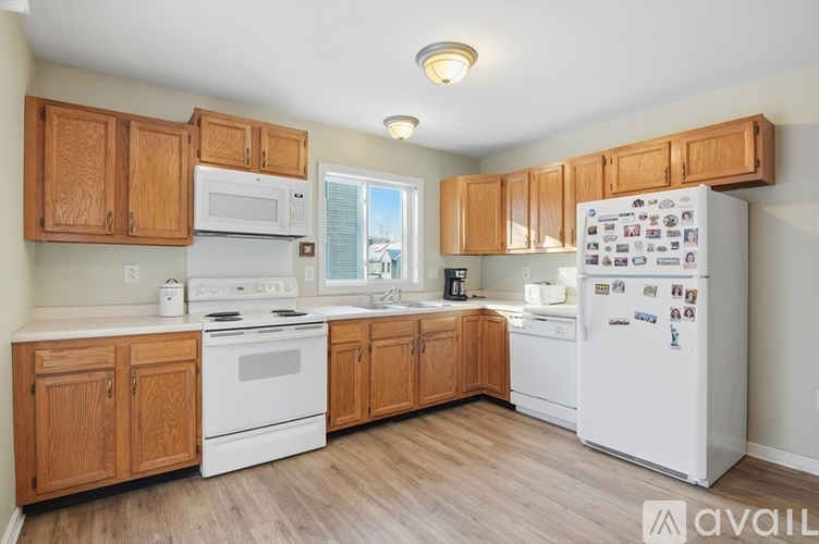 A kitchen with wooden cabinets and white appliances.