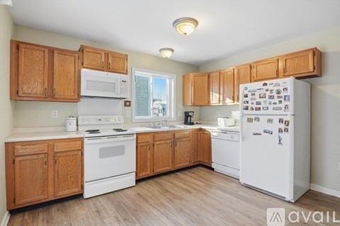 A kitchen with wooden cabinets and white appliances.